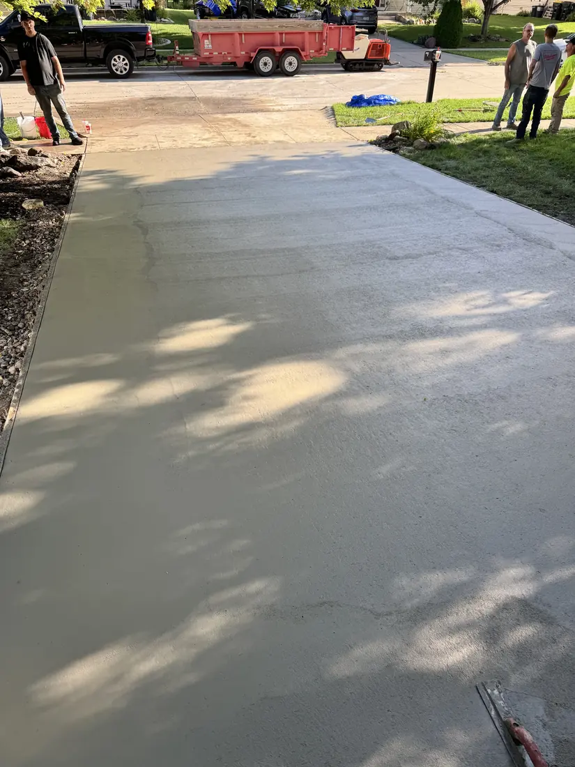 Freshly poured concrete driveway in Waukee, Iowa being floated and finished by the crew.