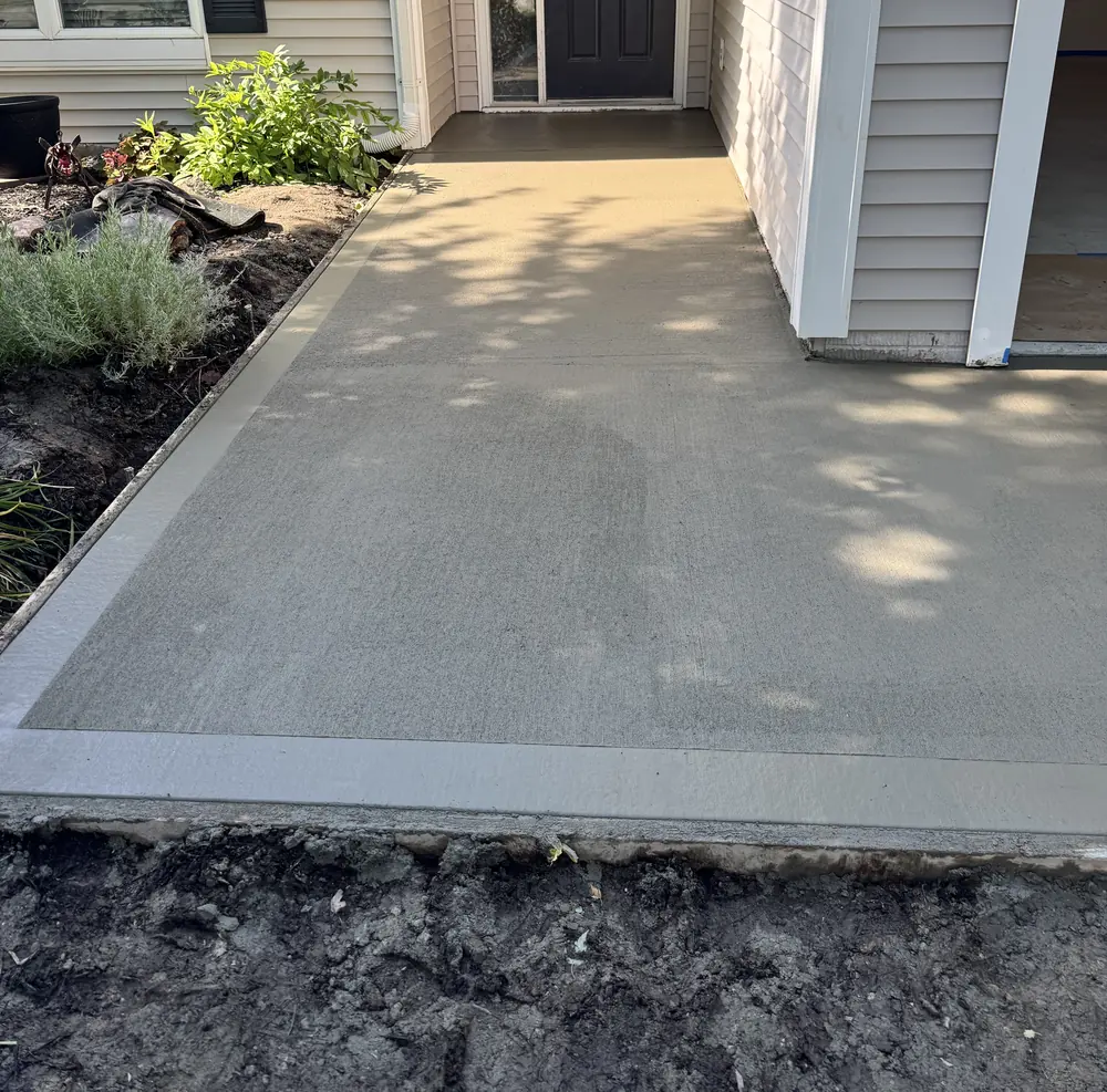 New concrete walkway and driveway approach in Waukee, Iowa leading to the front entry of the house.