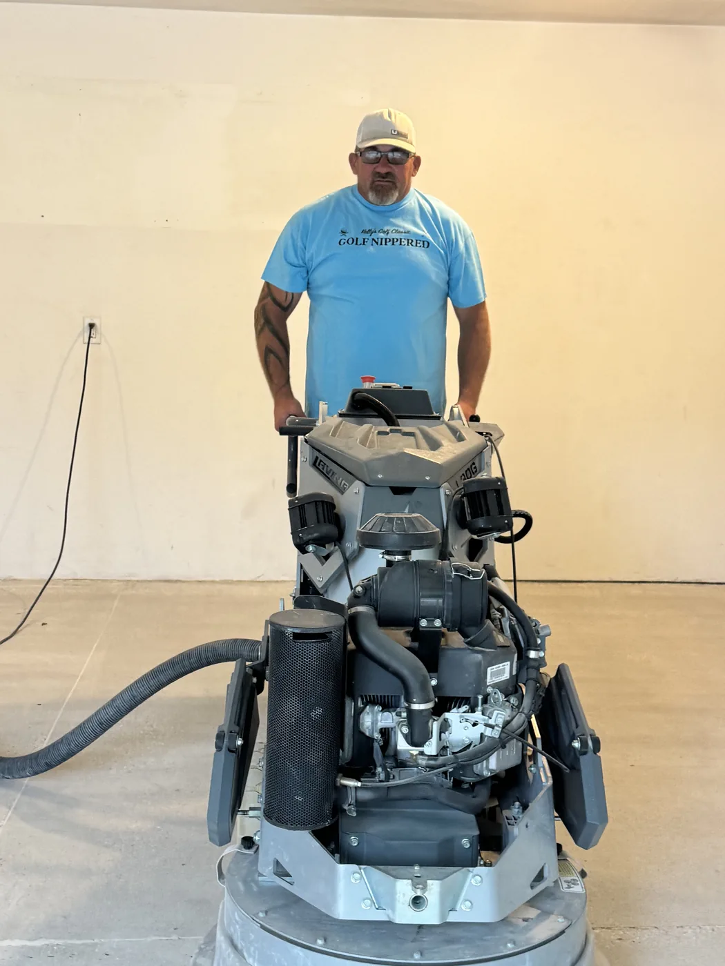 Diamond grinder with dust extraction opening the surface of a garage floor in Waukee, Iowa before coating.